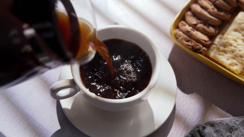 Fresh Brewed Hot Coffee Is Carefully Poured Into Cup. Filling Morning with Warm Aroma Comfort and Sense Of Peace. Simple Daily Ritual with Black Coffee that Highlights Flavor, Warmth And Relaxation 4k