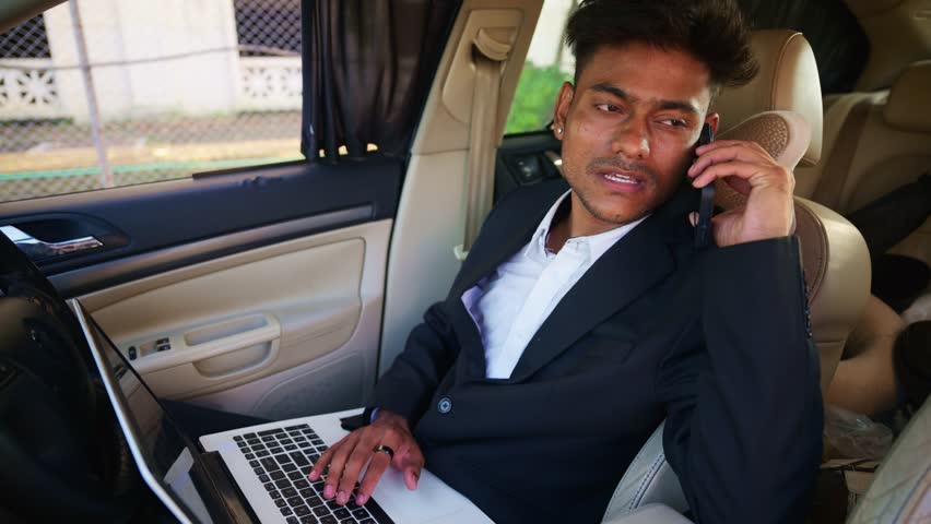 Young Executive Manages Work Remotely from Vehicle, Businessman in Suit Using Laptop and Phone Inside Car, Entrepreneur Multitasks Uses Tech Gadgets into Motorcar, Staff Balances his job via device