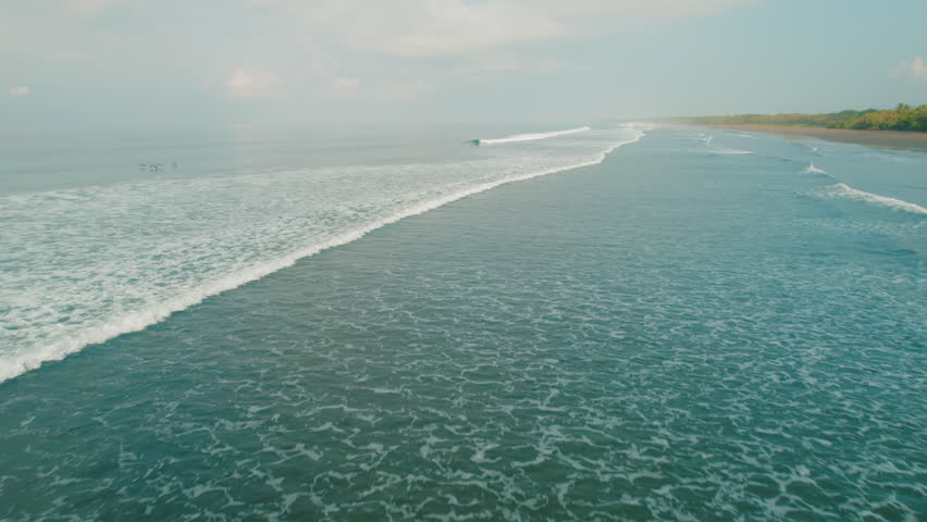 Ocean waves rolling toward sandy beach Playa Linda shore Puntarenas Costa Rica
