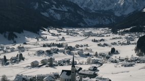 Picturesque Snowy Village and Traditional Church Nestled Below Dramatic Jagged Mountain Peaks - Powered by Shutterstock - Get 15% off with code: PIKWIZARD15