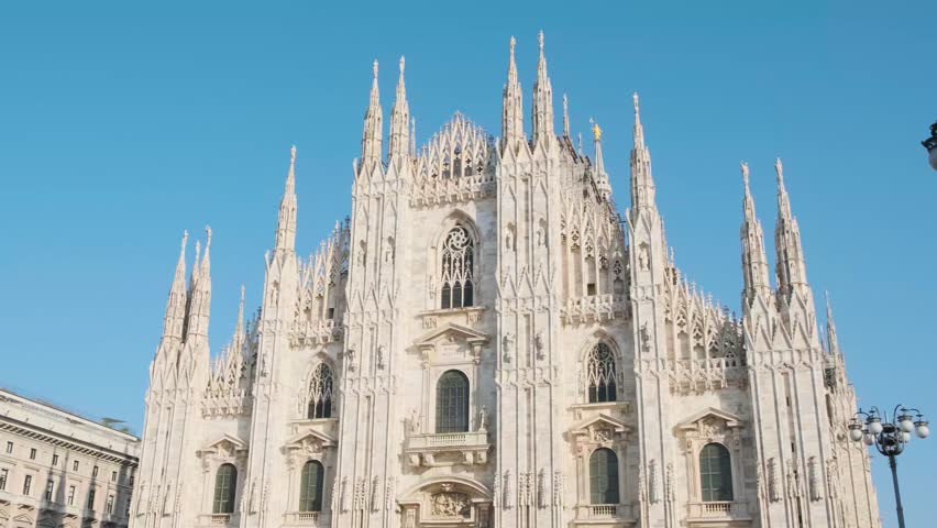Milan Cathedral on Cathedral square in sunny day, Milan, Lombardy, Italy. Piazza del Duomo with Duomo di Milano with intricate Gothic architecture. Travel and touristic landmark