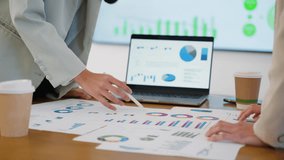 Business team collaborating on financial data and analytics in a modern office. Two colleagues are reviewing charts and graphs while discussing results with a laptop data visuals in the background - Powered by Shutterstock - Get 15% off with code: PIKWIZARD15