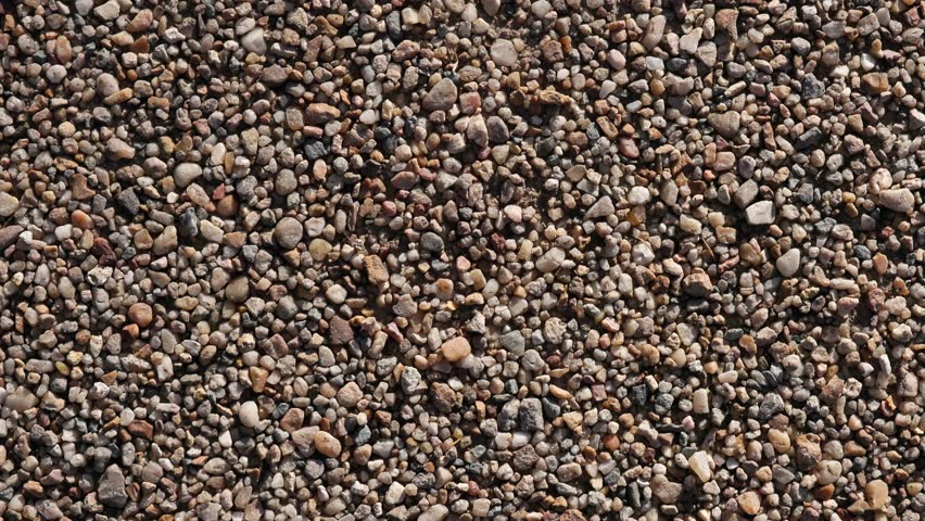 Seamless beige gravel background with small pebbles, ideal natural stone texture for titles, product presentations, 3D compositing and motion graphic overlays