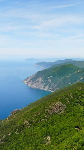 Vertical drone shot of the mountainous coastline of Liguria, summer day in Italy