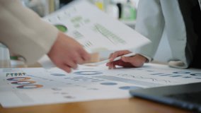 Business team collaborating on financial data and analytics in a modern office. Two colleagues are reviewing charts and graphs while discussing results with a laptop data visuals in the background - Powered by Shutterstock - Get 15% off with code: PIKWIZARD15
