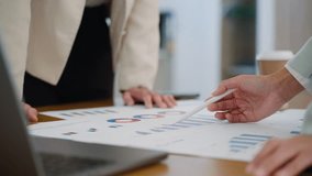 Business team collaborating on financial data and analytics in a modern office. Two colleagues are reviewing charts and graphs while discussing results with a laptop data visuals in the background - Powered by Shutterstock - Get 15% off with code: PIKWIZARD15