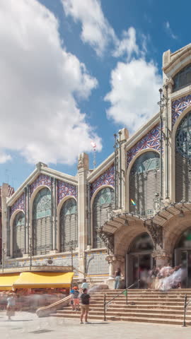 Valencia Central Market timelapse hyperlapse. Historic public market with stunning architecture, stained glass, dome and tile details. Located in Market Square near Santos Juanes Church. Spain