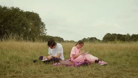 Teenagers sitting on grass drawing pictures together in park. Children focusing on creative sketches while enjoying outdoor activity. Boy and girl making artwork together in natural field - Powered by Shutterstock - Get 15% off with code: PIKWIZARD15