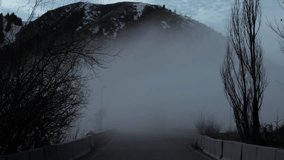 A mystical road to nowhere, a mountain track hidden by thick fog, leads to snow-capped peaks - Powered by Shutterstock - Get 15% off with code: PIKWIZARD15