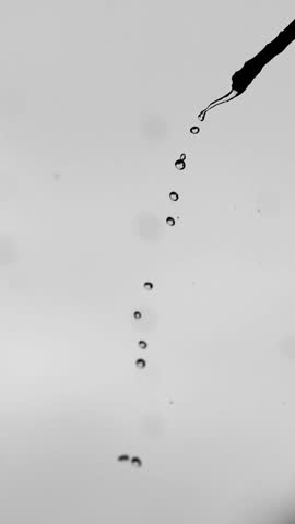 Vertical video clips for mobile Dynamic droplets: Capturing the elegance of fluid dynamics, the photo shows a stream of perfectly formed water droplets.