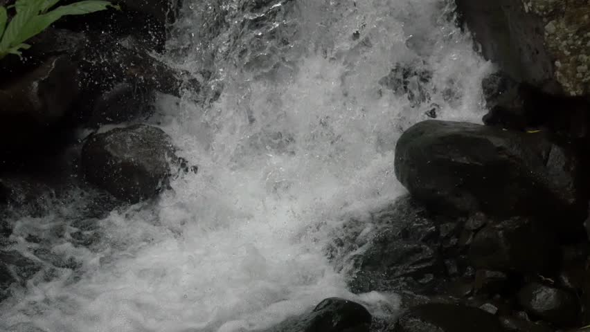 Steady rapid water pushing across rugged rocks endlessly.