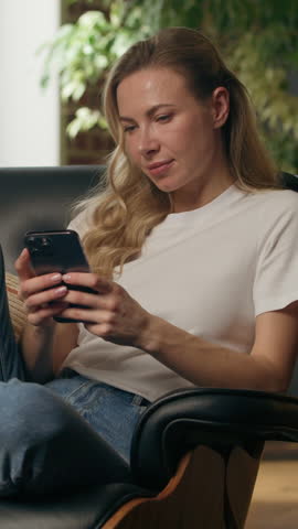 Pondering business woman using mobile phone thinking typing answer mobile phone at home Caucasian pensive female businesswoman freelancer sitting indoor browsing smartphone texting chat idea solution