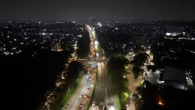 A stunning aerial night view of the city captured by drone, showcasing illuminated buildings and moving cars creating dynamic light trails along the busy roads - Powered by Shutterstock - Get 15% off with code: PIKWIZARD15