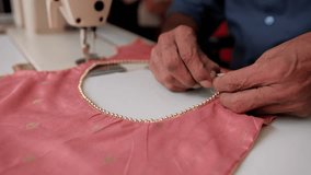 Skilled tailor adding golden beadwork to soft pink blouse, showcasing delicate artisan textile crafting technique - Powered by Shutterstock - Get 15% off with code: PIKWIZARD15
