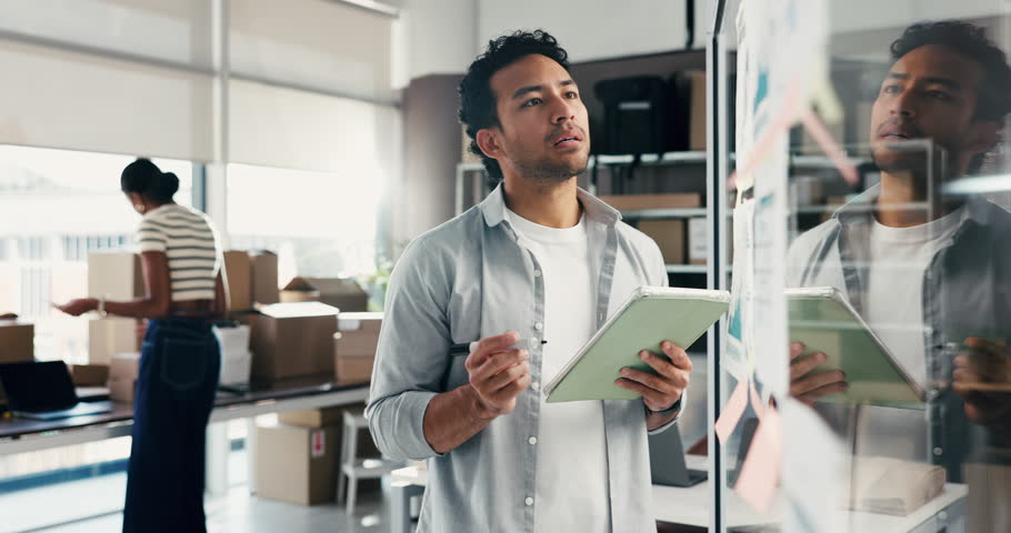 Businessman, writing or planning with tablet for logistics, supply chain or services on glass board. Man, distributor or supplier with technology or ideas for small business startup or distribution