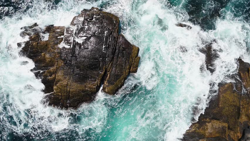 Cinematic Top View Shot Of Stormy Atlantic Coast In Nova Scotia Canada. Powerful Ocean Waves Crash Onto Rugged Cliffs Creating A Dramatic Scene Of Nature Force Along The Rocky Shoreline.