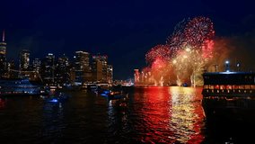 Fireworks over Manhattan at night. Bright fireworks erupt above the East River with Manhattan glowing in darkness - Powered by Shutterstock - Get 15% off with code: PIKWIZARD15