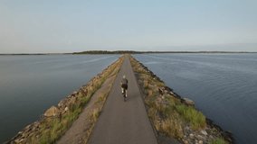 A cyclist rides along a coastal path beside the calm sea in Denmark, capturing an active lifestyle in a peaceful maritime landscape. - Powered by Shutterstock - Get 15% off with code: PIKWIZARD15