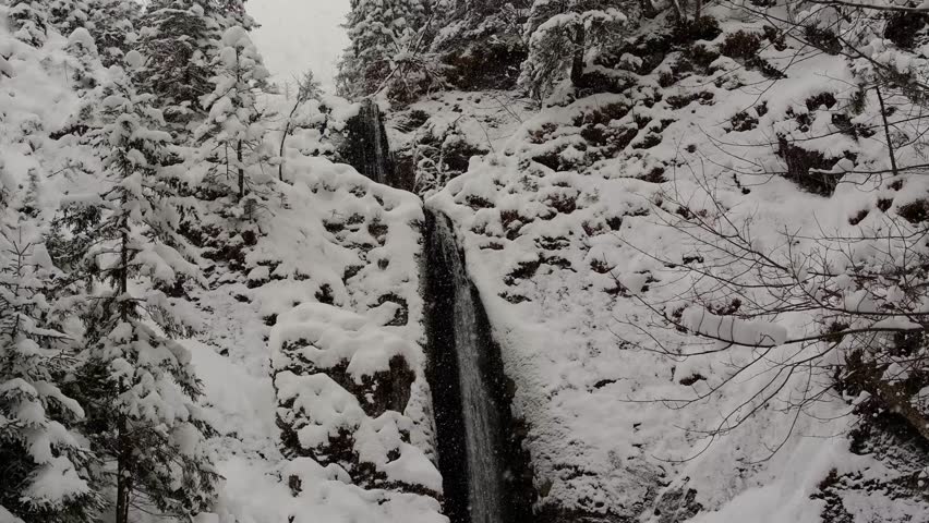 beautiful Siklawica waterfall during a snowfall in Zakopane, Poland.
