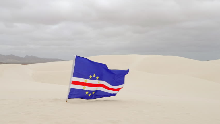 The Cape Verde flag flies in the Viana Desert, overcast day, Boa Vista island, Cape Verde.