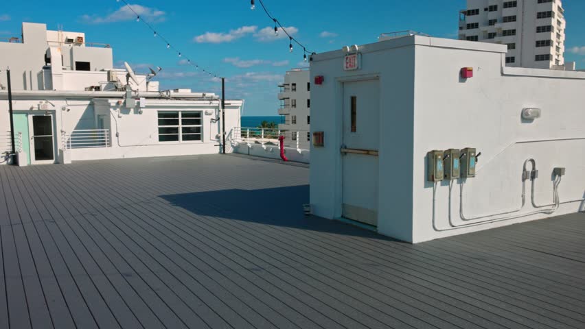 Beautiful view of hotel rooftop terrace with white walls and Atlantic Ocean on background. Miami Beach. USA. 
