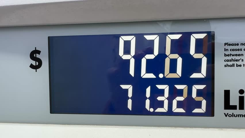 Fuel pump display tracking rising costs.Digital fuel pump screen counts liters and total price in real time, emphasizing fuel savings, oil price fluctuations and the impact of the ongoing energy risis