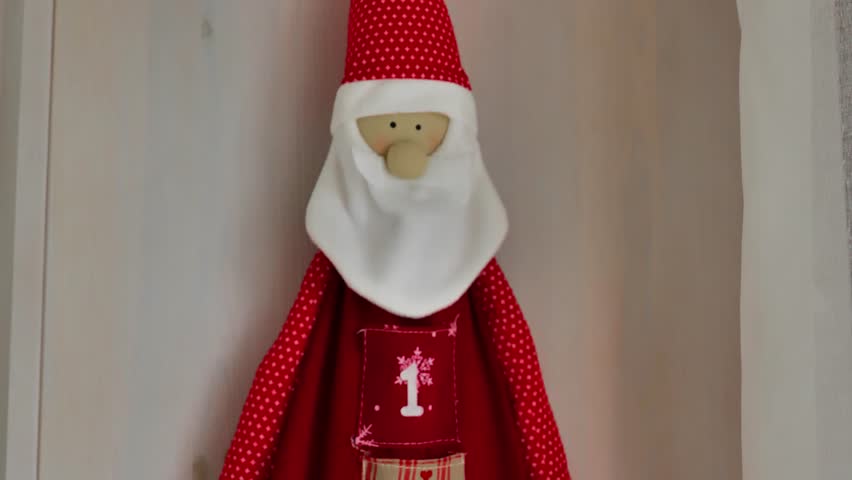 Santa Claus advent calendar.Red advent calendar with twenty-five pockets.Christmas surprises and gifts.Symbolic Christmas gifts.Preparing for the Christmas holidays. Winter customs and traditions