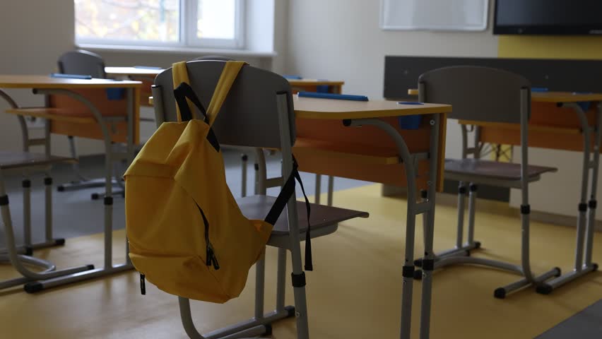 Stylish classroom with desks and chairs at school. Camera moving left