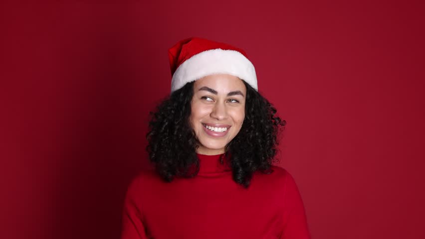 Attractive woman wearing Santa hat on red background. Christmas season