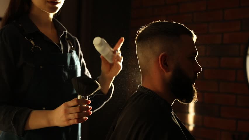 Hairstylist applying talcum powder with brush onto man's neck at salon, closeup
