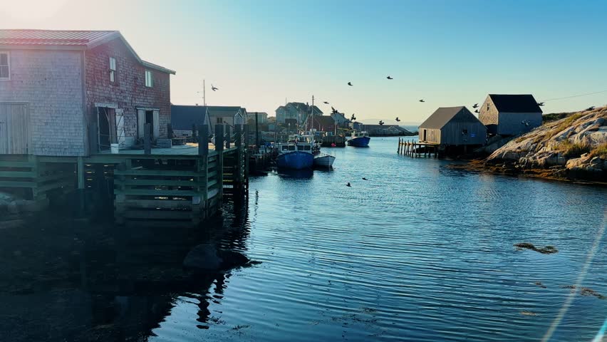 Cinematic View Of Peggys Cove Fishing Village Nova Scotia Canada. Charming Summer Evening Scene Featuring Fishing Boats Floating In The Bay And Traditional Wooden Houses Along The Shoreline.