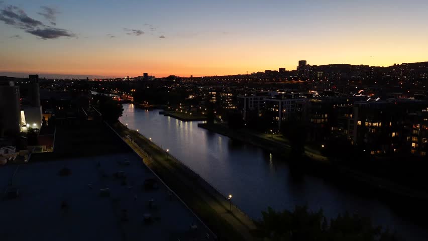Montreal skyline at dusk, city lights reflecting over water in Grifintown and downtown. g.