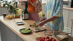 Teen brother and sister standing at kitchen counter cooking healthy smoothie with kiwifruit, using blender - Powered by Shutterstock - Get 15% off with code: PIKWIZARD15