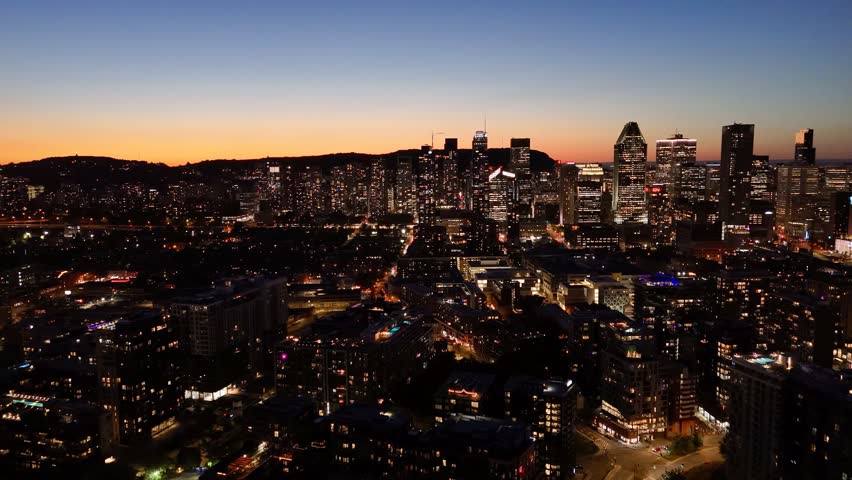 Montreal skyline at dusk, city lights reflecting over water in Grifintown and downtown. g.