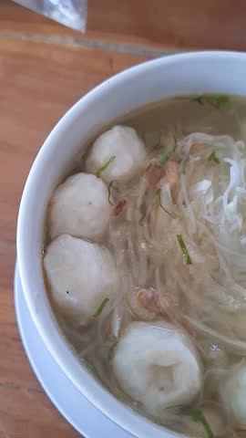 Close-up Video of Spicy and Sour Thai Tom Yum Soup (Tom Yum Goong) with Mushrooms and Aromatic Herbs, Concept of Southeast Asian Cuisine, Comfort Food, and Gourmet Soup