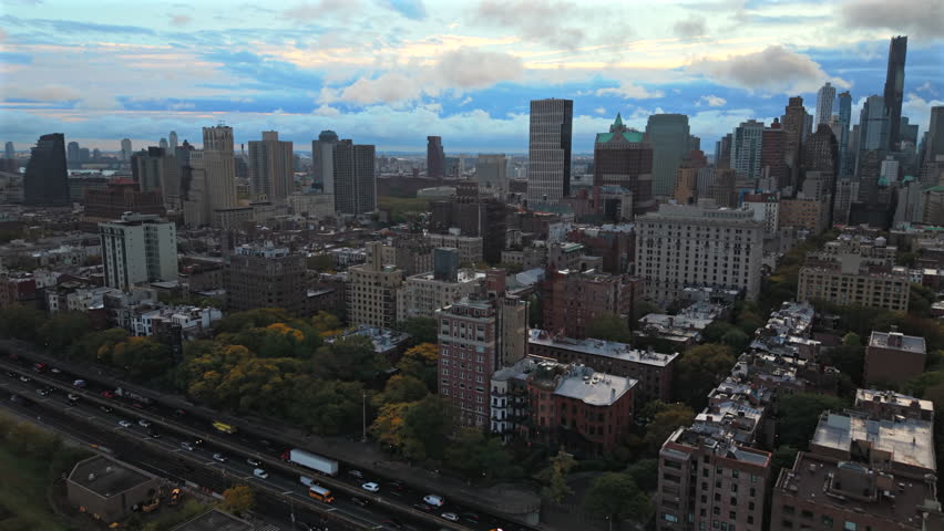 High aerial view of New York City, Brooklyn, New York showing dense residential blocks, tall skyline towers and layered cloudy daylight stretching across the city horizon. usa