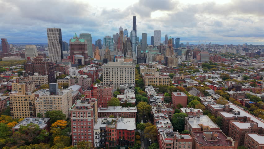 Cinematic Drone aerial shot of Manhattan, New York City, New York showing tall skyline towers, dense city blocks and cloudy daylight creating a wide panoramic urban perspective. USA