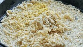 Stirring and pressing hard noodle block to absorb boiling water fully in bowl - Powered by Shutterstock - Get 15% off with code: PIKWIZARD15