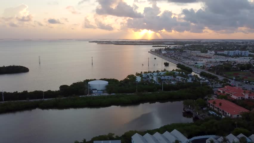 sunrise shot over Sand Point, Key West, showcasing warm horizon glow, calm coastal waters, and the quiet early-morning landscape from an elevated aerial view