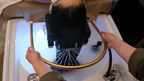 Spa therapist washing the clients hair with gentle movements during a calming wellness head spa treatment - Powered by Shutterstock - Get 15% off with code: PIKWIZARD15