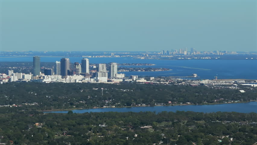 Expansive aerial view showcasing Downtown Saint Petersburg skyline in foreground with Downtown Tampa visible across Tampa Bay, highlighting Florida