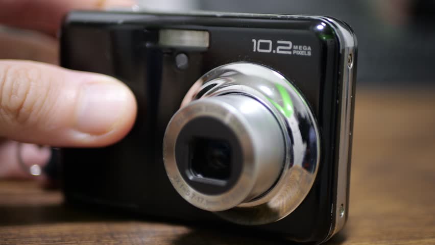 Digital Photo Camera in Photographer Hands on Table, Built-In Lens Focusing with Audible Clicks, Precision Optical Adjustment, Mini Camera Operation, Realistic Household Gadget Focus Sound