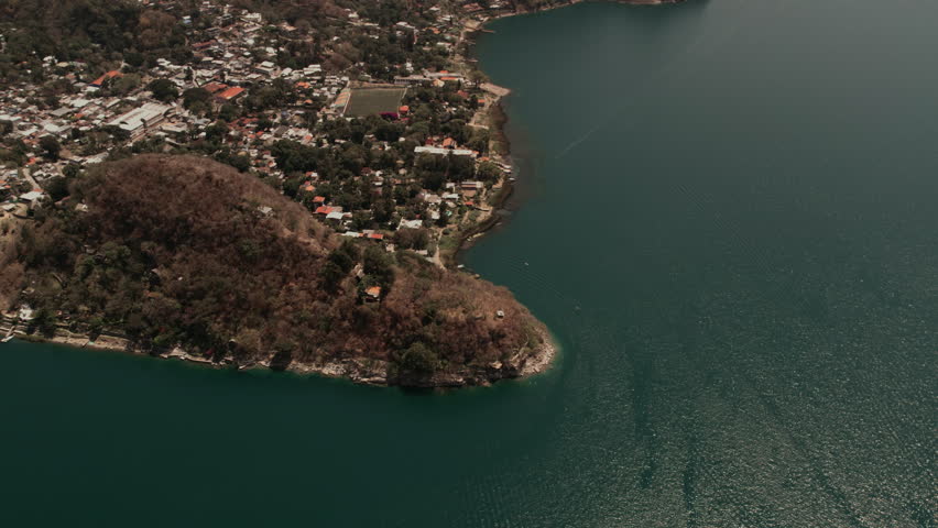 Profile view of a small town situated beside a quiet sea. Drone shot.