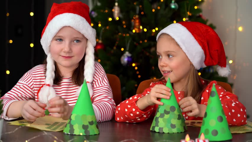 Happy kids fun make diy gifts Christmas tree from paper stickers for Christmas. Holidays leisure with children. Craft handmade. New Year