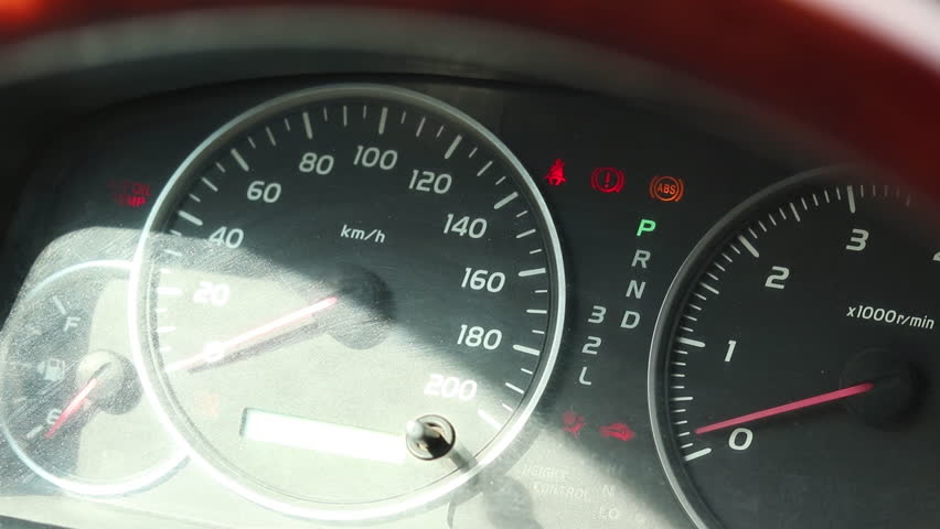 Closer up of a car dashboard with instruments like a speedometer, tachometer and burning lights. The engine revs and the pointer of the tachometer goes up. Mechanic testing the car after fixing engine