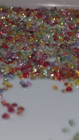 Colorful loose gemstone sparkling on white tray. Jewelry and gems business of selling