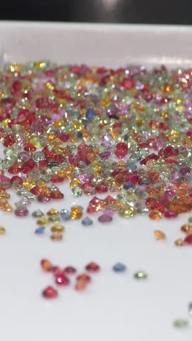 Colorful loose gemstone sparkling on white tray. Jewelry and gems business of selling