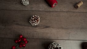 Slow motion camera sliding right over wooden surface featuring centered copy space surrounded by pinecones and holiday decor - Powered by Shutterstock - Get 15% off with code: PIKWIZARD15