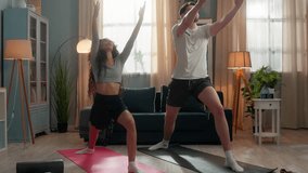 Multiracial couple doing yoga at home sport family exercising practicing asana poses stretching morning habit sporty Hispanic woman female fitness girl wife and Caucasian guy man male husband stretch - Powered by Shutterstock - Get 15% off with code: PIKWIZARD15