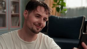 Happy smiling Caucasian man talking phone video call after sport workout at home cheerful tired sweaty guy male sportsman using mobile app talk conference virtual conversation blog showing thumb up - Powered by Shutterstock - Get 15% off with code: PIKWIZARD15